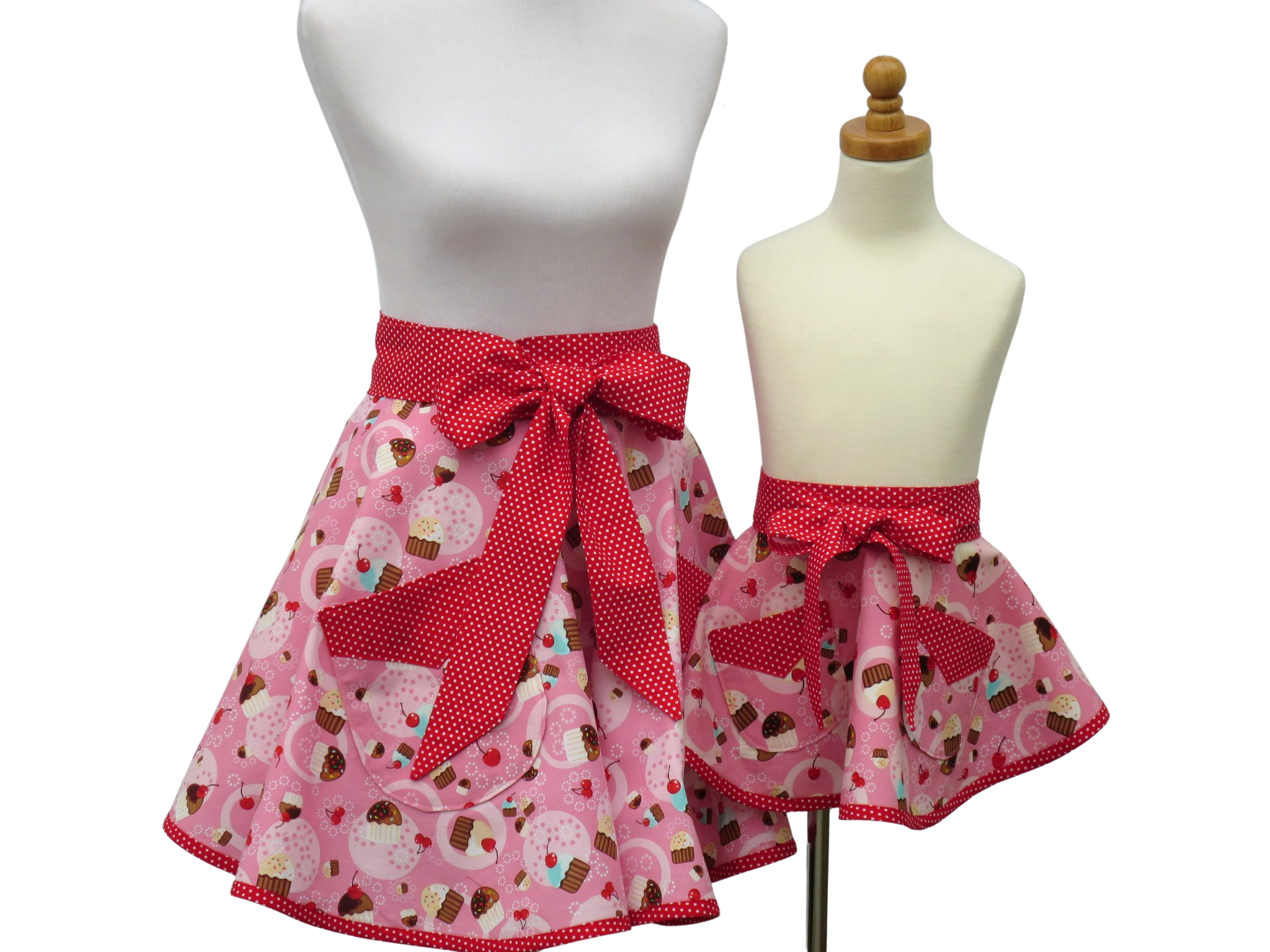 https://www.stitchedbybeverly.com/sites/stitchedbybeverly.indiemade.com/files/mother_daughter_pink_half_cupcake_apron_set_front_view_tied_in_front.jpg
